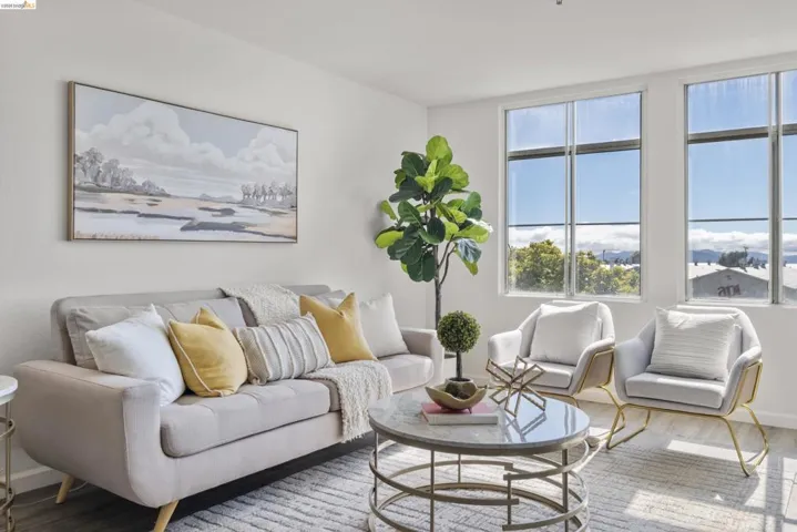 Bright living area featuring expansive windows, wood-finish flooring, and a contemporary light fixture