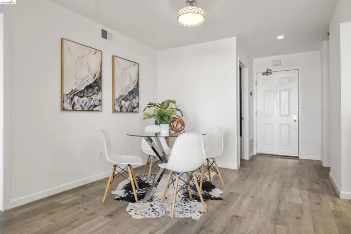 Open dining area featuring wood-finish flooring and a contemporary overhead light fixture