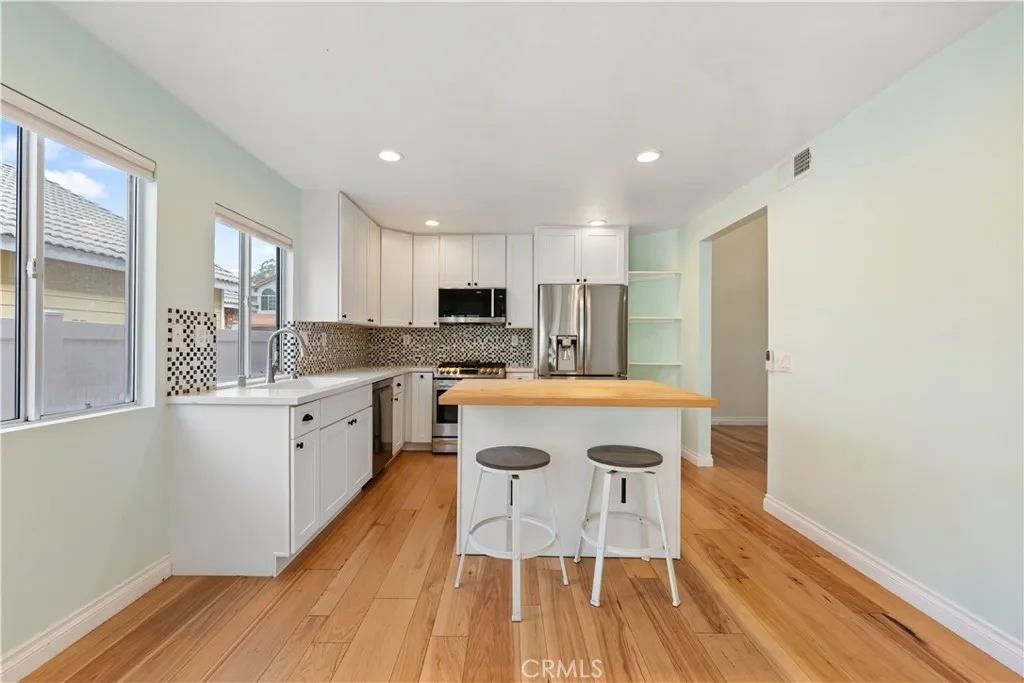 Kitchen with with floors, recessed lighting & a center island on wheels.