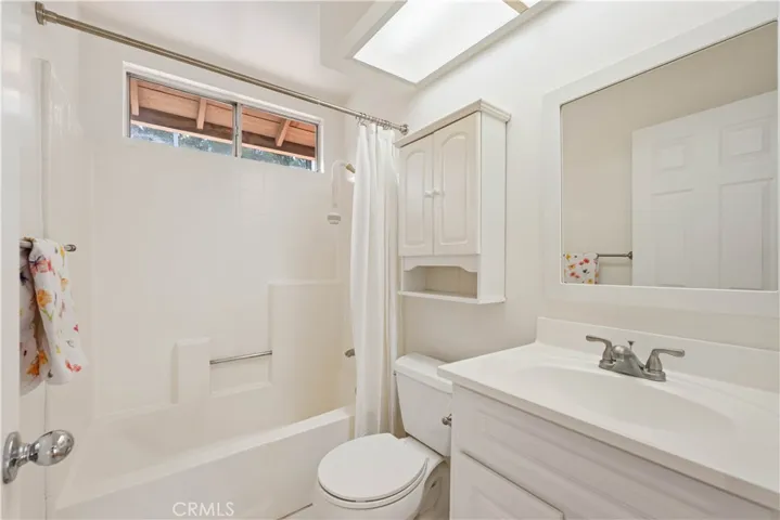 Full bath with upgraded vanity & a tile floor.