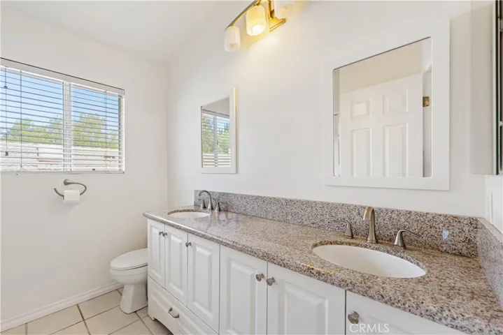 Primary bath with upgraded large vanity with double sinks & a tile floor.