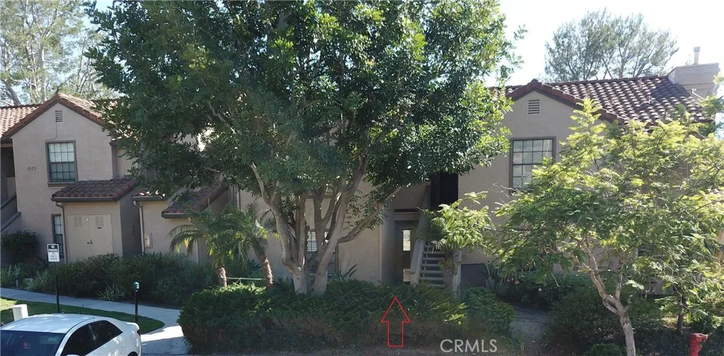 View of well maintained building, grounds of Vista Pacifica.  See arrow - home down the walkway.