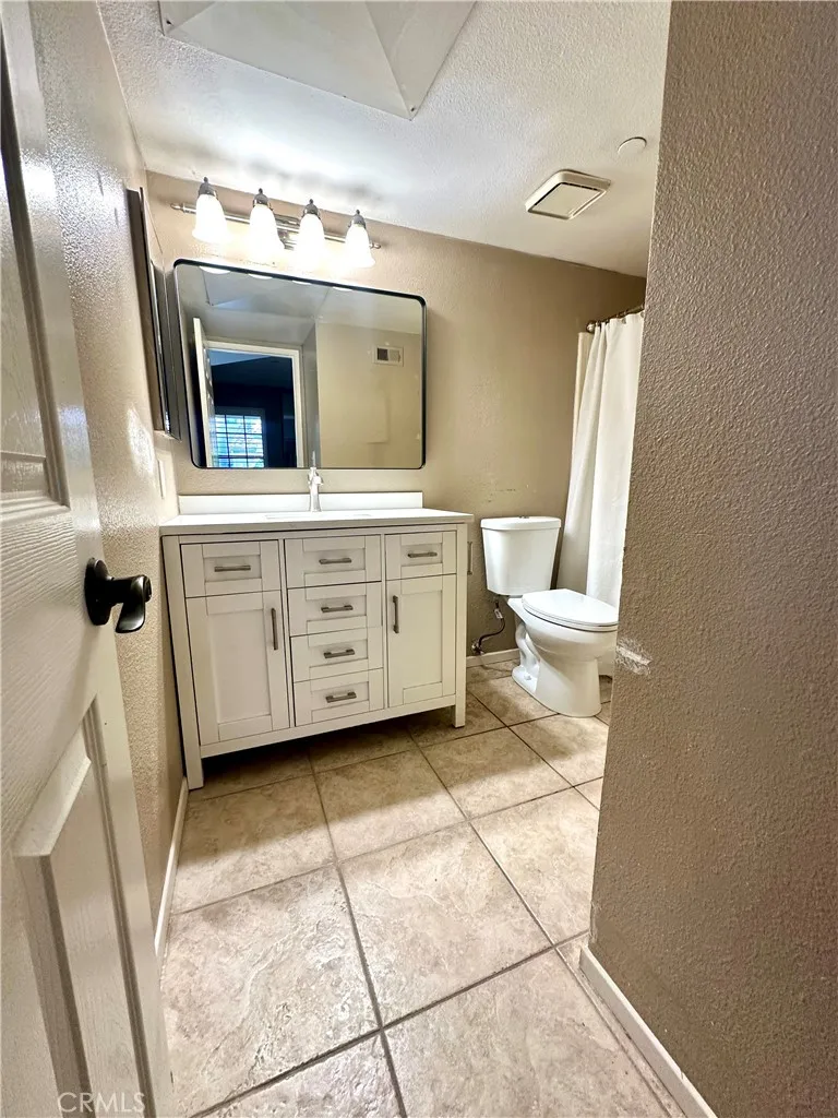 Primary bathroom with new vanity, toilet, mirror & updated lighting