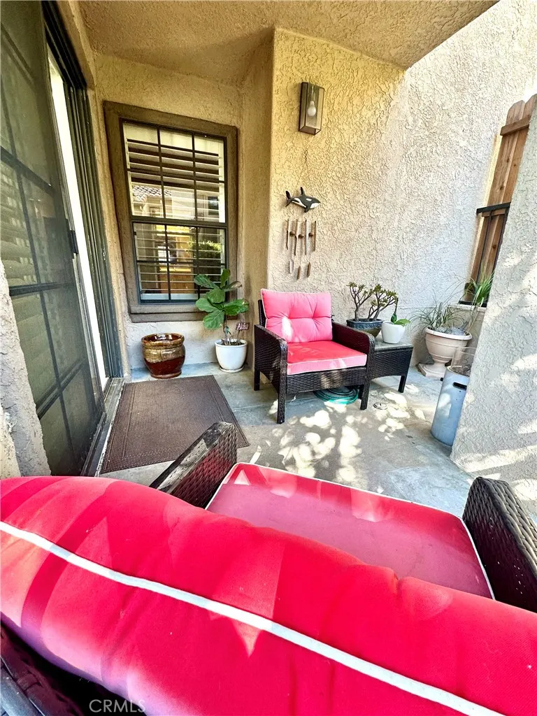 Large Private patio looking back towards home.  The window is the primary bedroom. Slider to living room on left. Stream runs behind patio. Perfection