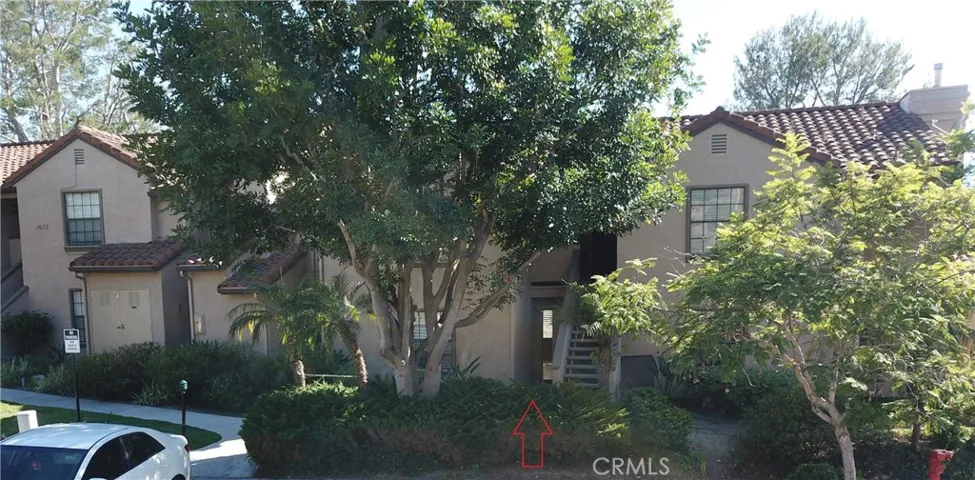 View of well maintained building, grounds of Vista Pacifica.  See arrow - home down the walkway.