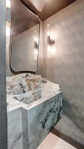 Elegant powder room with imported Italian marble vanity and designer wallpaper.