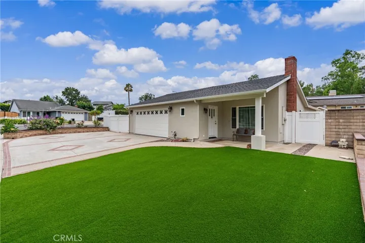 Inviting single-story home featuring an oversized driveway and low-maintenance landscaping.