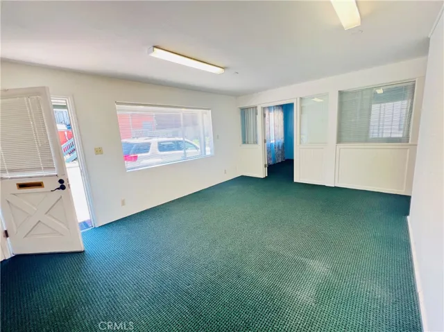Looking towards the separate space beyond the door. Privacy curtains and back door exit to parking area.