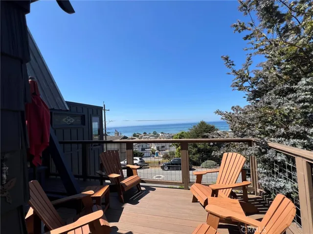 Patio on front of house with seating and an umbrella~