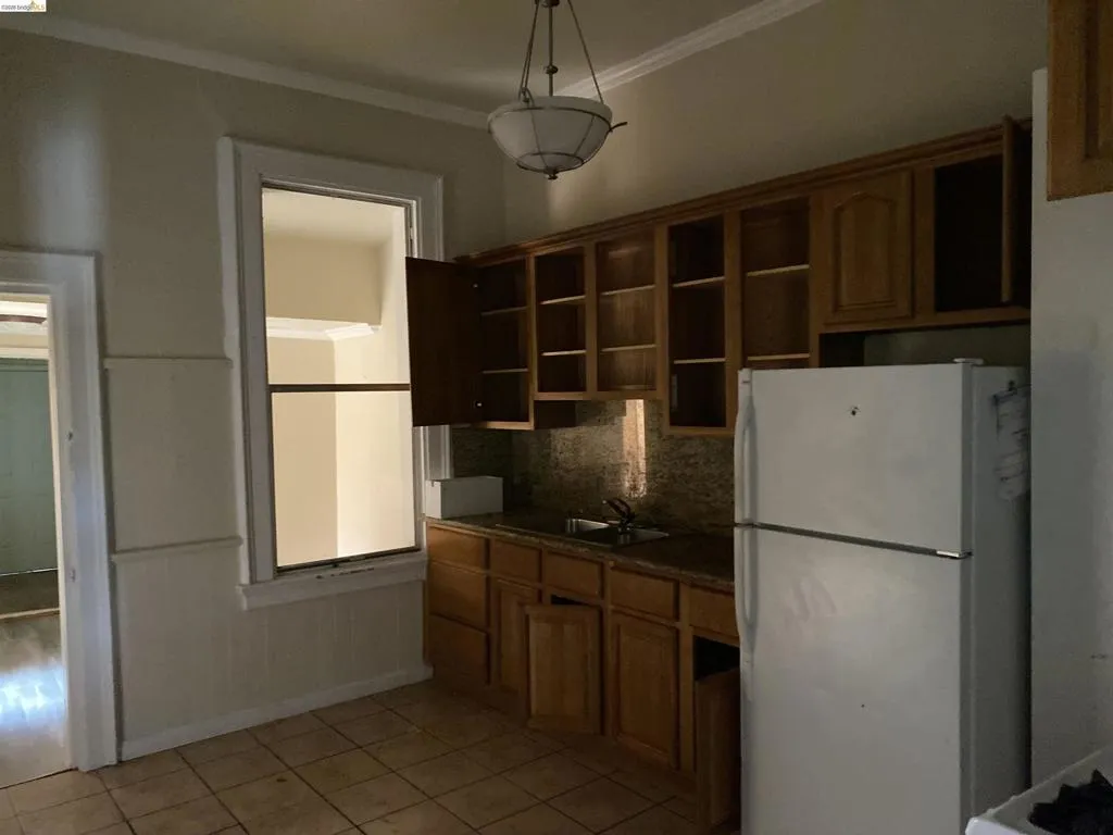 Kitchen featuring wood-finish cabinetry, tile flooring, and a large window