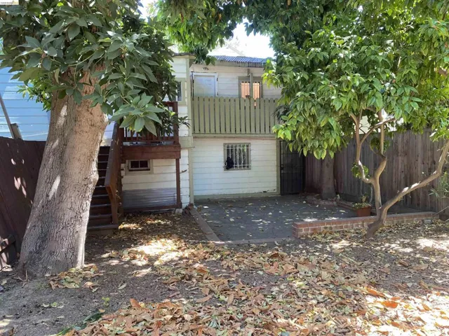 Private outdoor space featuring a ground-level patio, mature trees, and a wooden fence perimeter