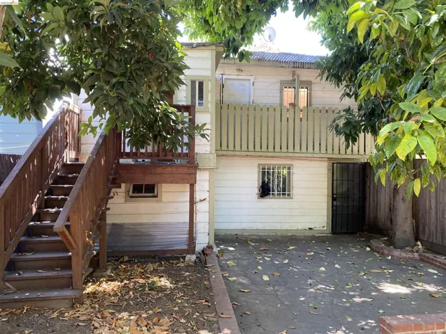 Two-story rear building featuring white siding and a wood-slat balcony