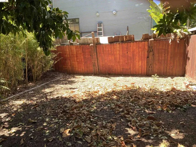 Expansive outdoor space featuring a wood fence, mature bamboo plantings, and a ground-level watering system