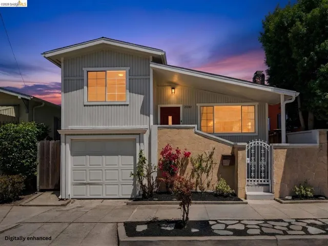 Modern exterior with light gray siding, an attached garage, a private entry gate, and stone accent walls