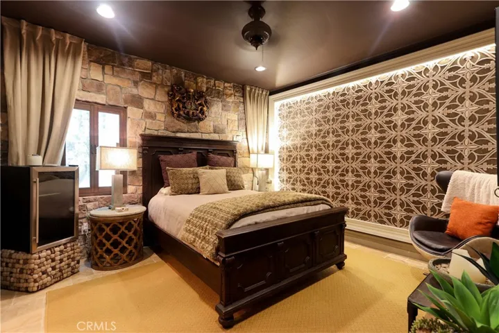 Bedroom 1 / Downstairs. There is a window to the front yard behind the lighted tapestry
