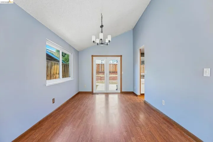 Interior space featuring wood-finish flooring, vaulted ceiling, and light blue walls
