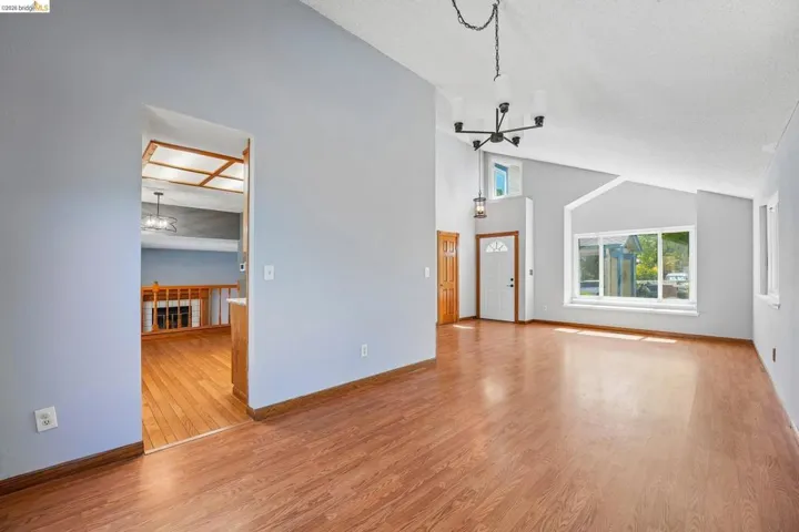 Spacious interior featuring vaulted ceilings and wood-finish flooring