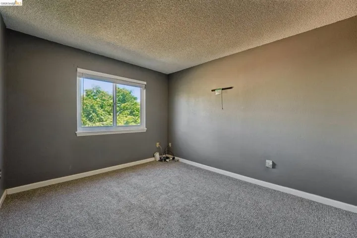 Room featuring gray walls, white trim, and light gray carpet