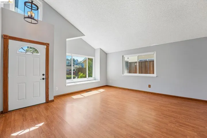 Vaulted ceilings elevate this space featuring wood-finish flooring