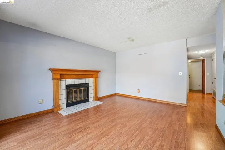 Living area featuring a fireplace with a wood mantle, white tile surround, and a black firebox