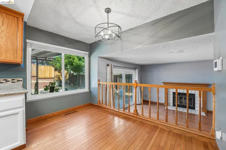 Light wood-finish flooring provides a warm base for this area, featuring a large window and a contemporary ceiling fixture