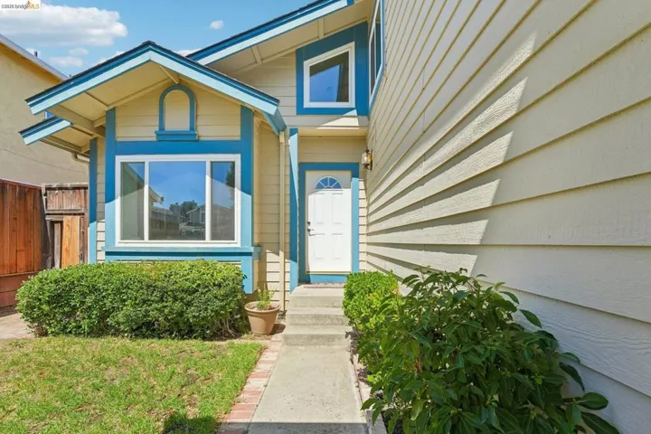 Exterior featuring light yellow siding with blue trim accents