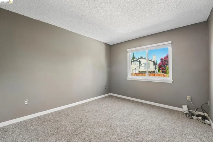 Interior room with light gray walls, white trim, and gray carpet