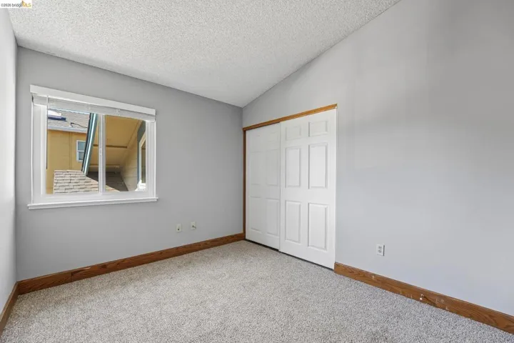Room featuring light gray walls, white trim window with blinds, and light gray carpet flooring