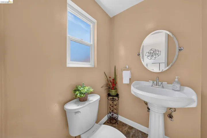 Pedestal sink with chrome fixtures and an oval mirror