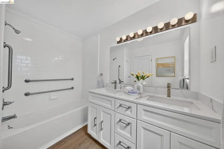 Dual vanity featuring white shaker cabinetry, integrated rectangular sinks, and a large mirror