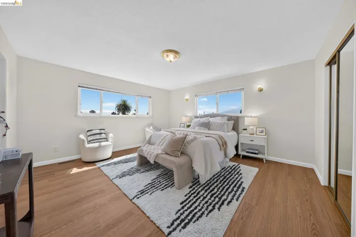 Spacious room featuring wood-finish flooring, light-colored walls, and a multi-pane window