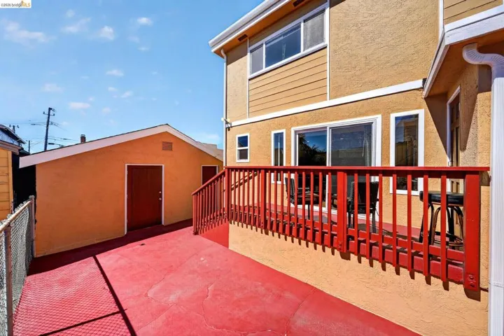 Exterior patio with red-painted concrete flooring and matching wooden railings