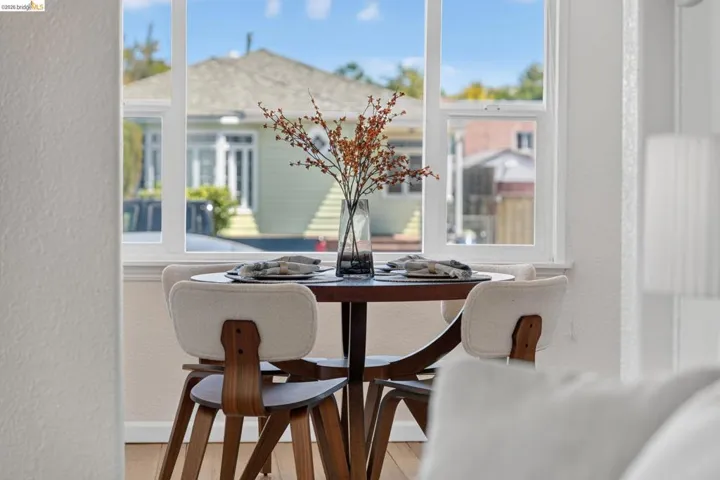 Bright interior space featuring a double-hung window with white trim, light-toned walls, and wood-finish flooring