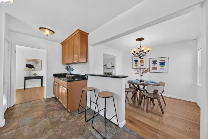 Kitchenette with natural wood cabinetry and a dark stone-finish countertop