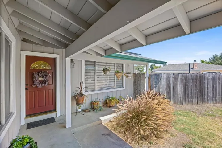 covered front porch and entry discreetly tucked away from street view offers privacy and curb appeal