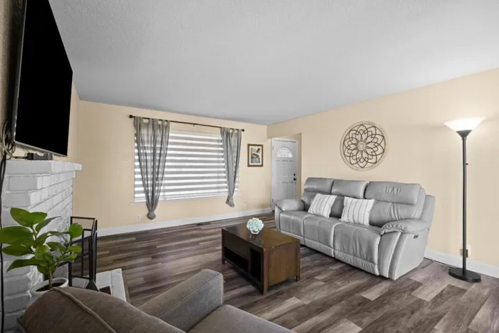main living room features a fireplace w natural light from picture window and slider to back yard