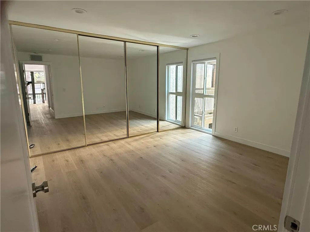 Primary bedroom including large, mirrored slider closet and dual pane window.