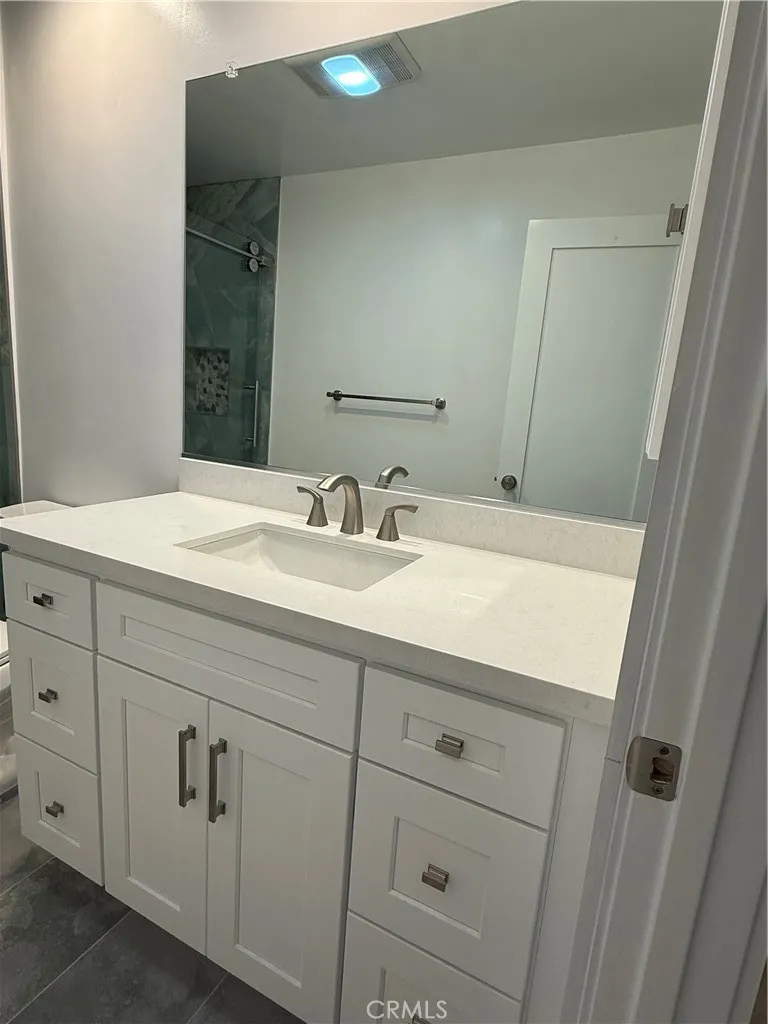 Another view of main bathroom including large vanity mirror.