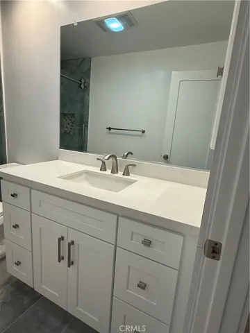 Another view of main bathroom including large vanity mirror.