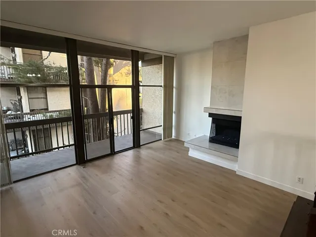 View of living room, large windows, sliders and living room fireplace.