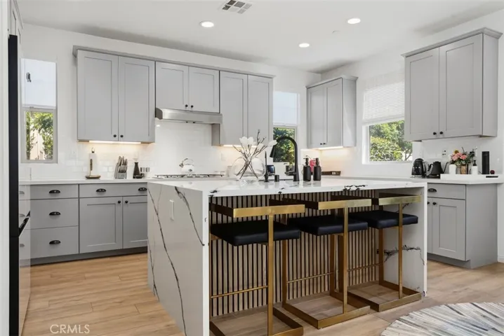Designed to impress, the completely transformed kitchen is anchored by a stunning waterfall-edge marble island with a custom wood slat accent. An unforgettable centerpiece that elevates the entire space.