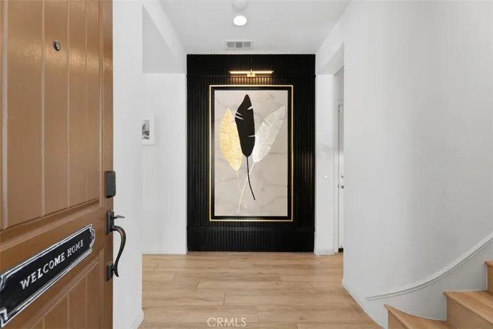 An impressive custom architectural slat feature wall welcomes you inside, creating a striking first impression that sets the tone for the home's thoughtfully curated designer finishes.