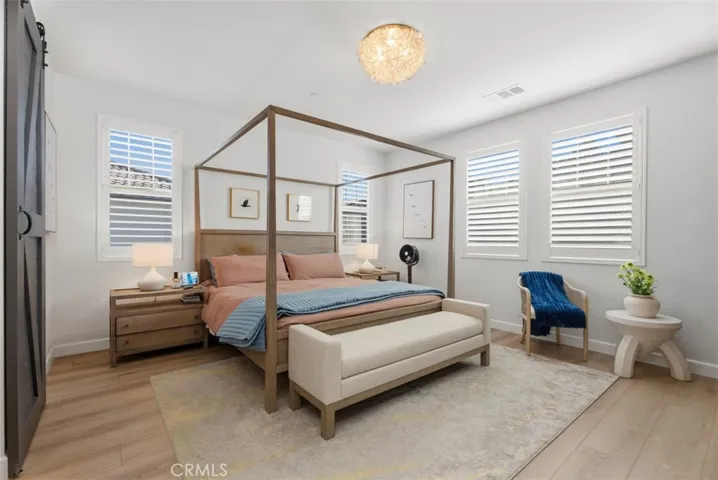 The spacious primary suite offers a relaxing retreat with room for a king-size bed and additional seating, creating the perfect place to unwind. The large walk in closet has a custom designed built in organization system