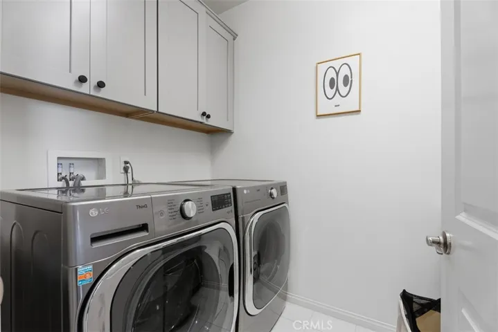 Convenient upstairs laundry room with built-in cabinetry keeps everyday chores organized and close to the bedrooms.