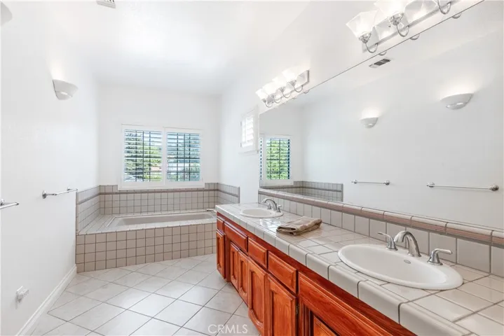 This primary bath has a soaking tub, lots of lighting and dual sink vanity