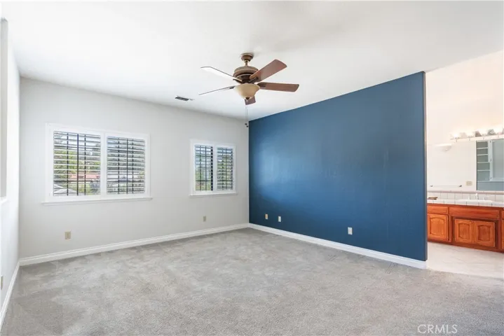 A very spacious primary bedroom with large windows
