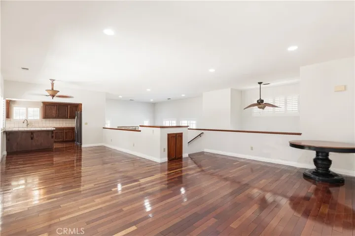 This large family room is open to the dining area and kitchen, all with wood flooring