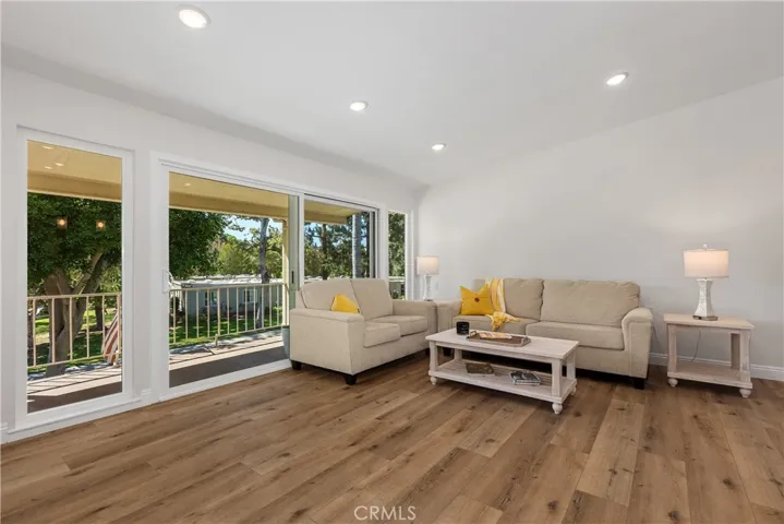 Great room with a wall of windows & slider out to balcony
