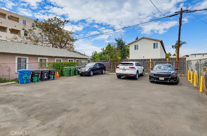 Rear of Building.  4 Parking Spaces & Possible Additional Parking left of the trash cans.