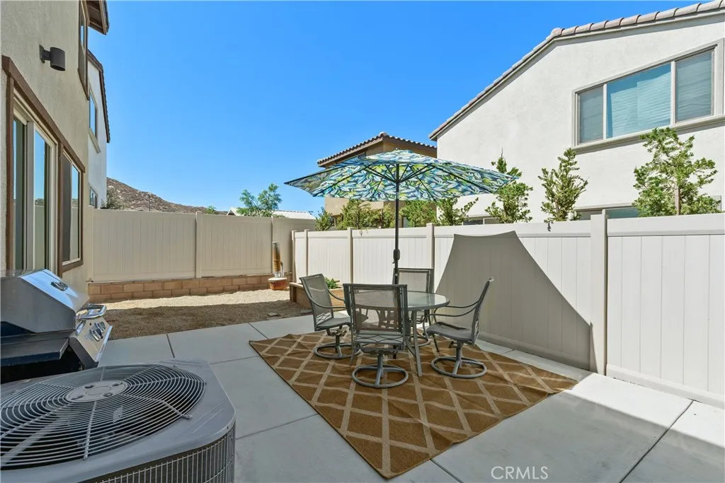 Large patio yard with concrete pad and vinyl fencing.